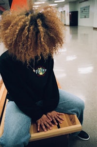 a woman sitting on a bench in a hallway