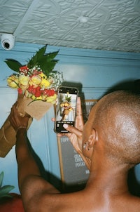 a man taking a picture of a bouquet of flowers